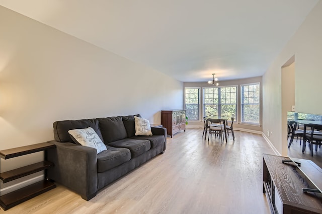 living room with light hardwood / wood-style flooring and a notable chandelier