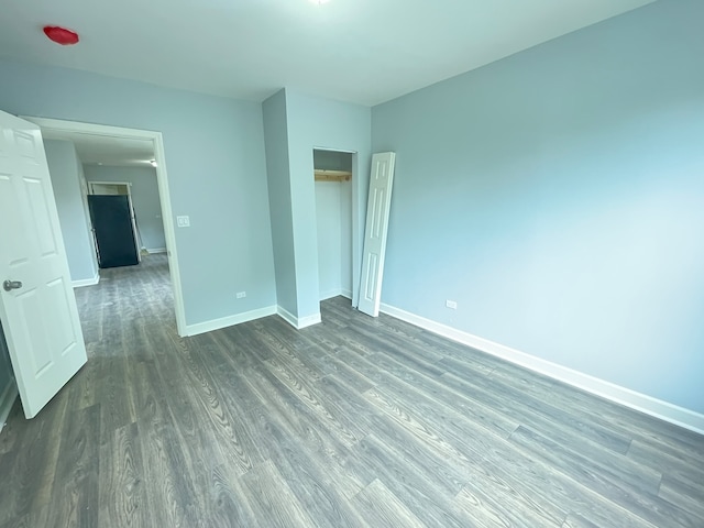 unfurnished bedroom with dark hardwood / wood-style flooring