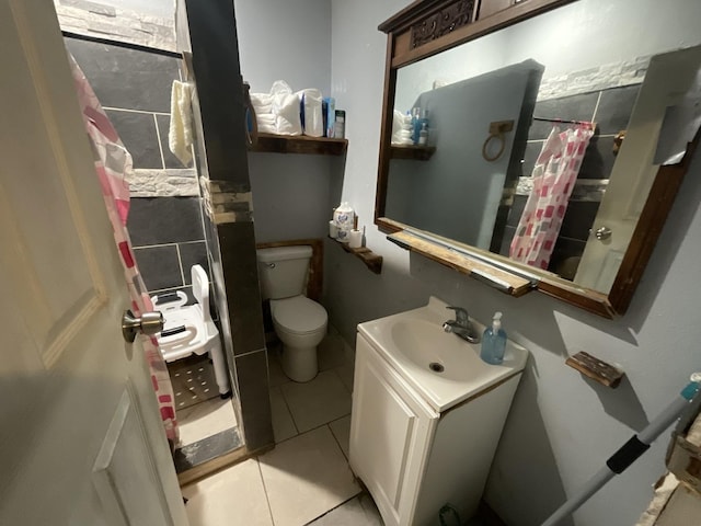 bathroom with toilet, vanity, and tile patterned floors