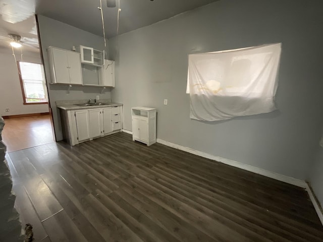 kitchen featuring dark hardwood / wood-style floors, ceiling fan, white cabinetry, and sink