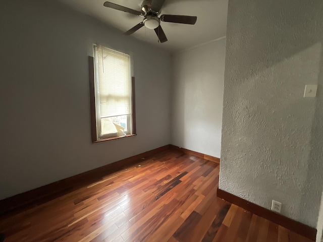 spare room with ceiling fan and dark wood-type flooring