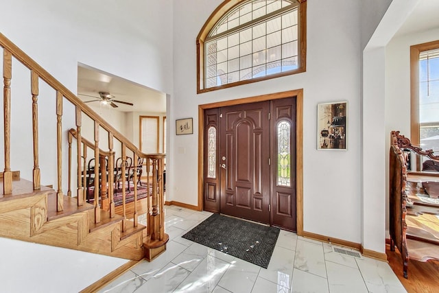 entrance foyer featuring a towering ceiling and ceiling fan