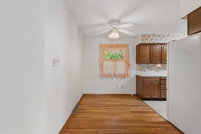 kitchen featuring white fridge, ceiling fan, tasteful backsplash, and light wood-type flooring