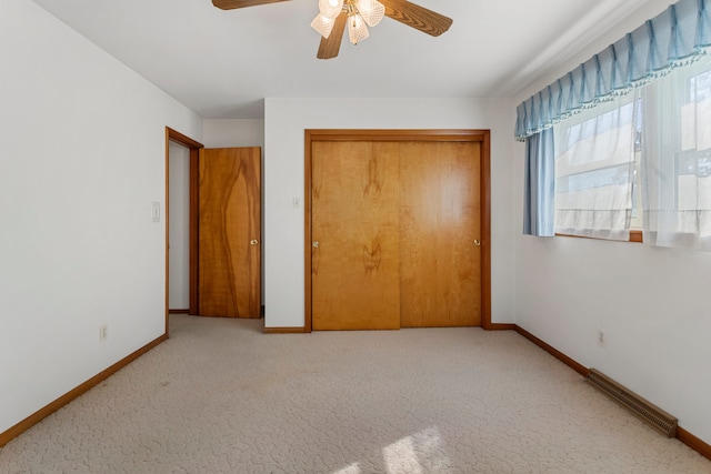 unfurnished bedroom with a closet, ceiling fan, and light carpet