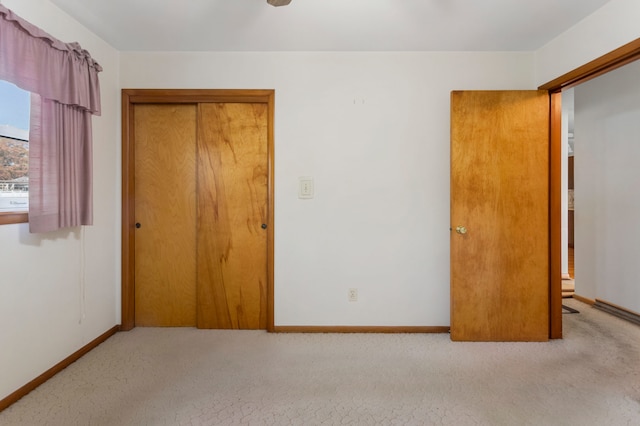 unfurnished bedroom with a closet and light colored carpet