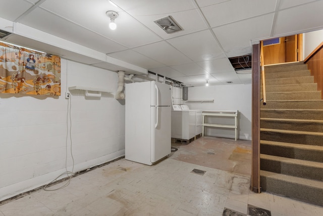 basement with washer / dryer, a paneled ceiling, and white fridge