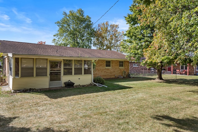 rear view of house featuring a yard