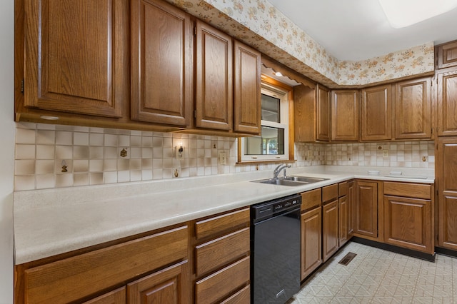 kitchen featuring black dishwasher, sink, decorative backsplash, and light tile patterned floors