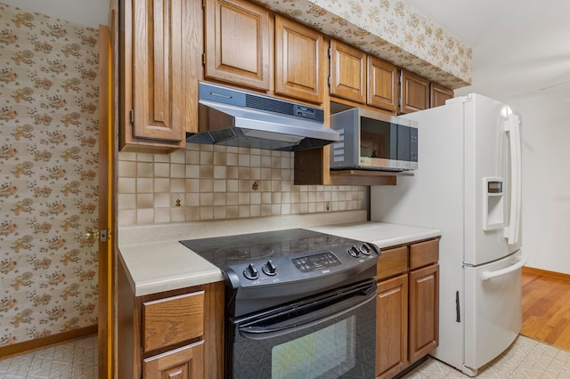 kitchen featuring light hardwood / wood-style floors, white fridge with ice dispenser, decorative backsplash, and electric range