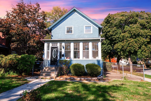 view of front facade featuring a yard and a sunroom