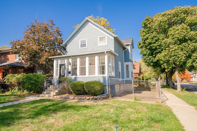 view of front property with a front lawn and a sunroom