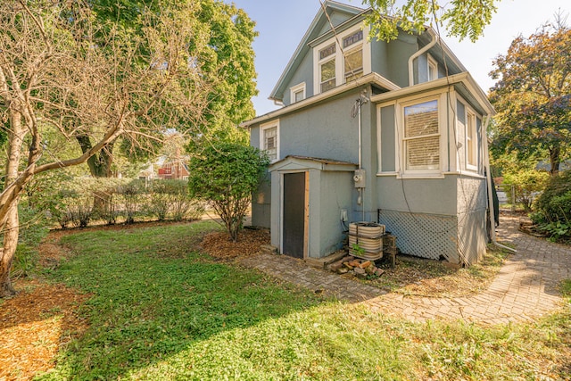 back of property featuring central air condition unit and a yard