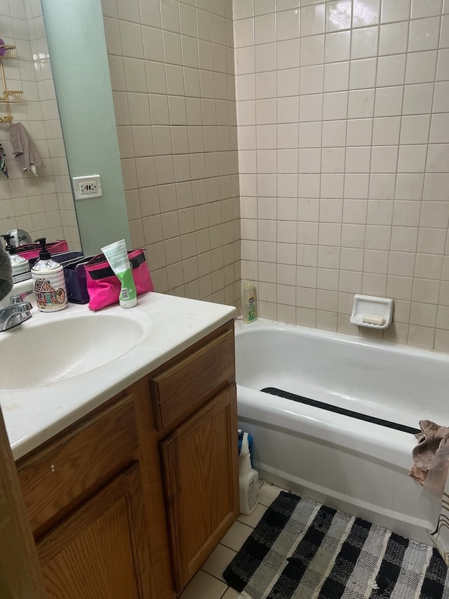 bathroom featuring vanity, tiled shower / bath, and tile patterned flooring