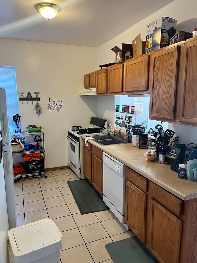 kitchen featuring sink, light tile patterned floors, and white appliances