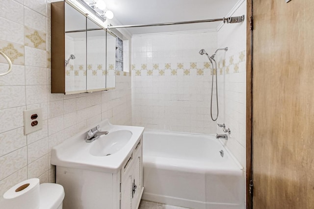 full bathroom with backsplash, vanity, tiled shower / bath combo, tile walls, and toilet