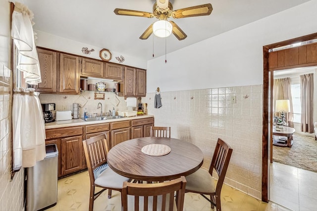 kitchen with ceiling fan, tile walls, and sink