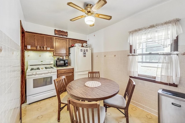 kitchen with white appliances, tile walls, and ceiling fan