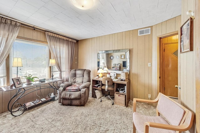 living area featuring carpet and wood walls