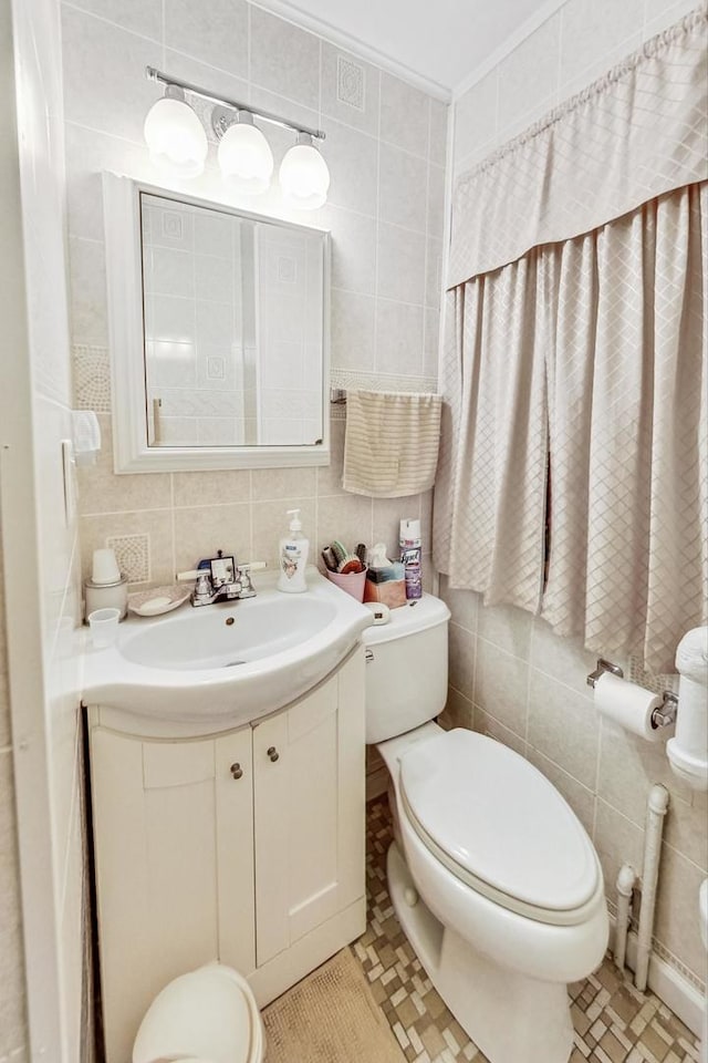 bathroom featuring decorative backsplash, vanity, and tile walls