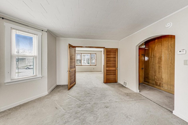 carpeted empty room featuring crown molding