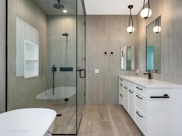 2118 N Clifton Ave, Chicago, IL 60614 - bathroom with vanity, wood finished floors, tile walls, a freestanding bath, and a stall shower