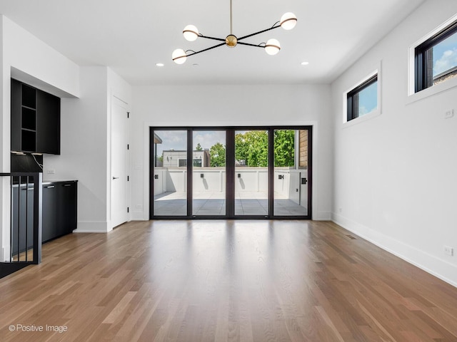2118 N Clifton Ave, Chicago, IL 60614 - unfurnished living room featuring plenty of natural light, light wood-type flooring, and an inviting chandelier