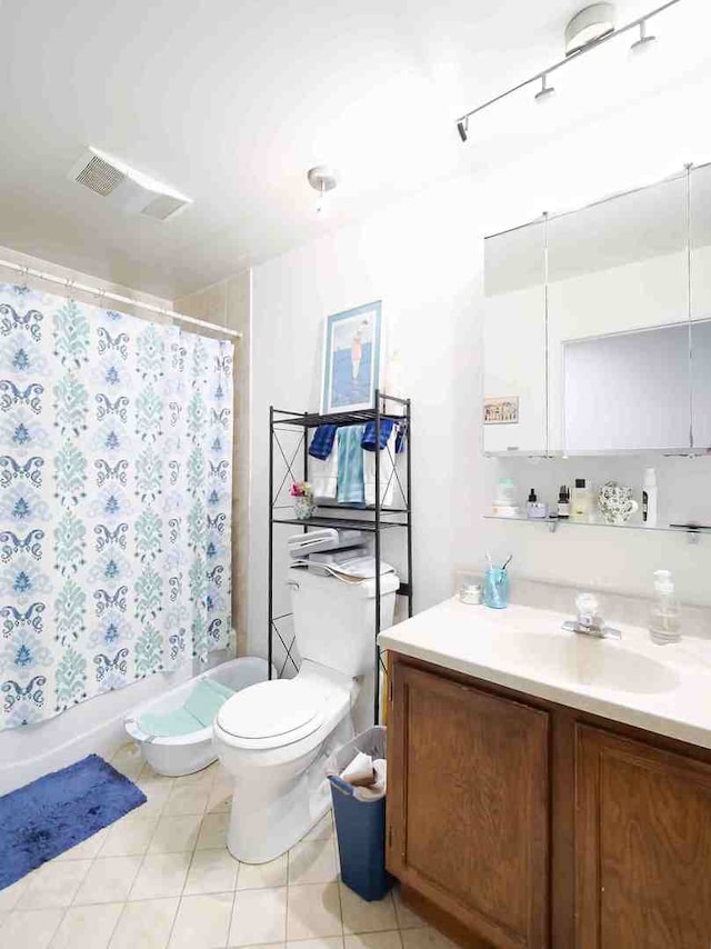 full bathroom with vanity, toilet, shower / bath combo with shower curtain, and tile patterned flooring