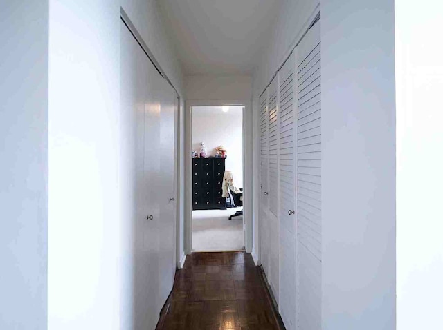 hall featuring dark parquet flooring