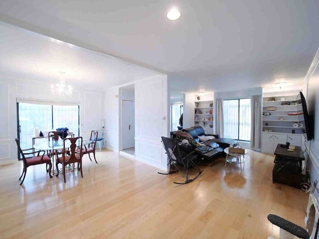 living room featuring light hardwood / wood-style flooring and an inviting chandelier