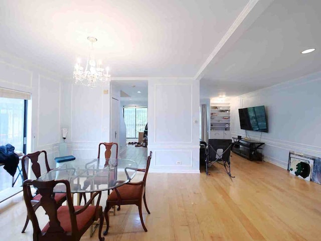 dining space featuring ornamental molding, a wealth of natural light, a chandelier, and hardwood / wood-style floors