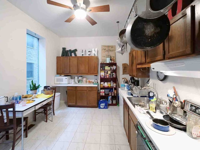 kitchen with stainless steel electric stove, sink, and ceiling fan