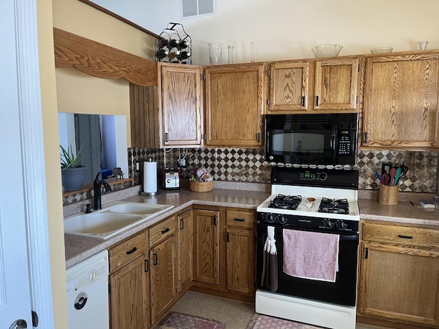 kitchen with gas range, white dishwasher, sink, and decorative backsplash