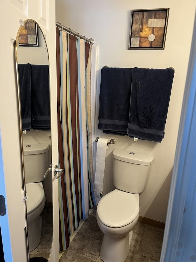 bathroom featuring a shower with shower curtain and toilet