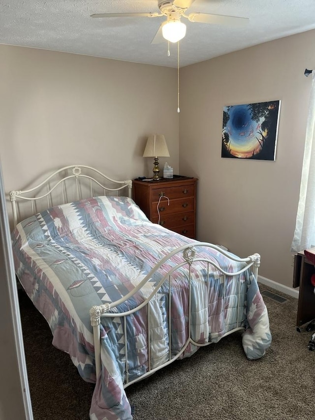 carpeted bedroom featuring ceiling fan and a textured ceiling