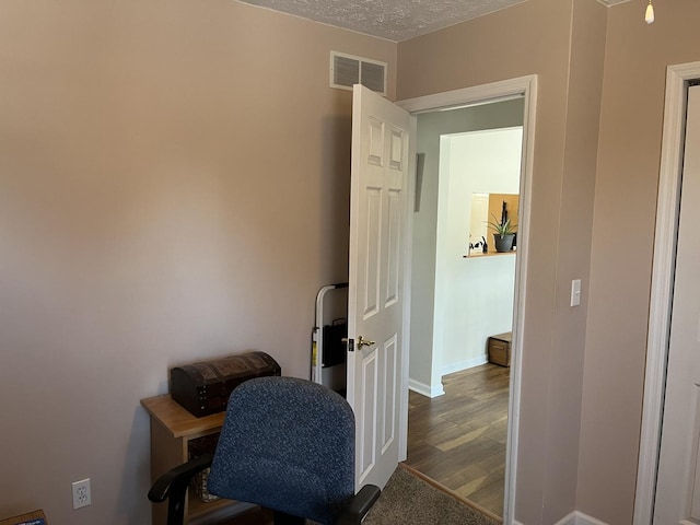 hallway featuring hardwood / wood-style floors and a textured ceiling