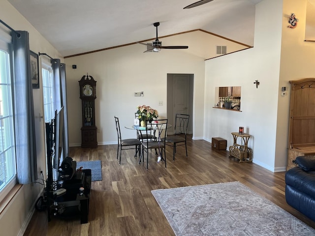 dining room with dark hardwood / wood-style flooring, crown molding, high vaulted ceiling, and ceiling fan