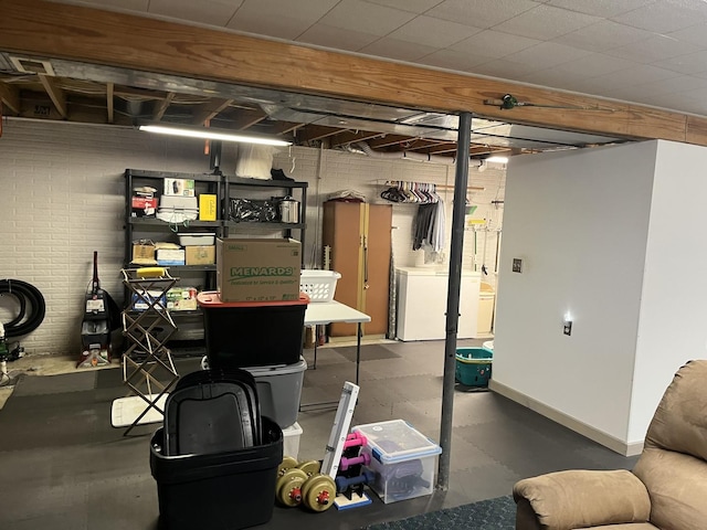 basement with brick wall and washer / clothes dryer