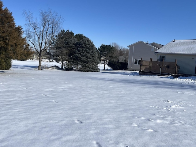 snowy yard featuring a wooden deck