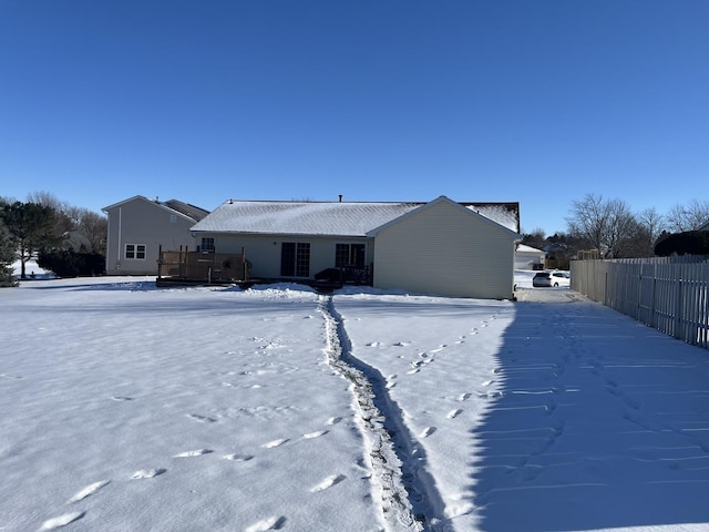 snow covered house with a wooden deck