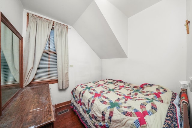 bedroom with lofted ceiling and dark hardwood / wood-style floors