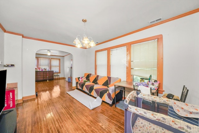 living room featuring crown molding, ceiling fan with notable chandelier, and hardwood / wood-style floors