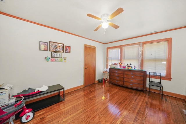 living area with hardwood / wood-style floors, crown molding, and ceiling fan