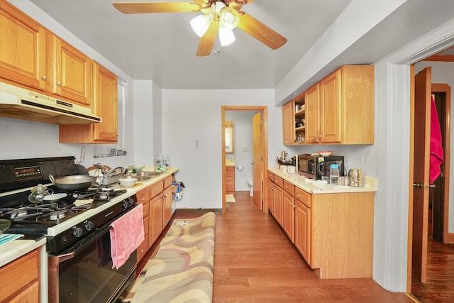 kitchen featuring black range with gas cooktop, sink, light hardwood / wood-style floors, and ceiling fan