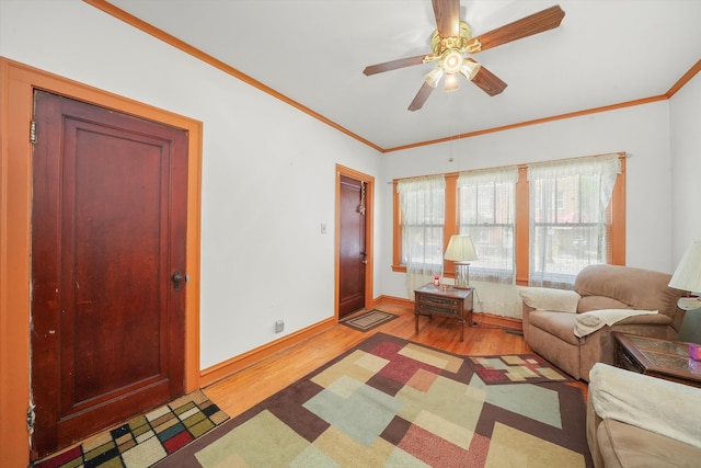 living room with crown molding, light hardwood / wood-style flooring, and ceiling fan