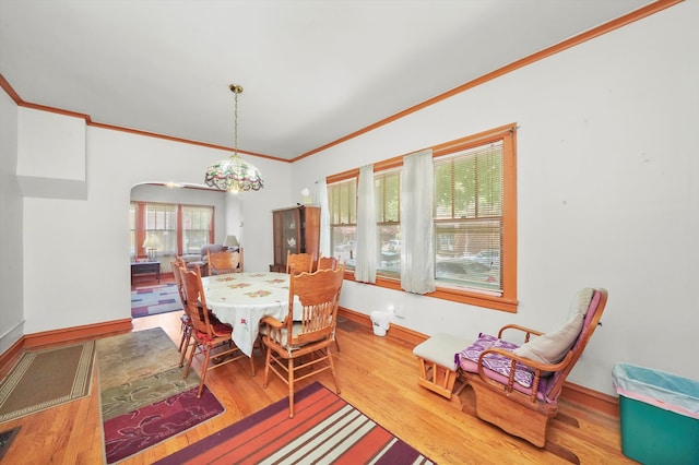 dining space with wood-type flooring and ornamental molding