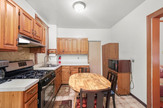 kitchen with sink, decorative backsplash, and gas range