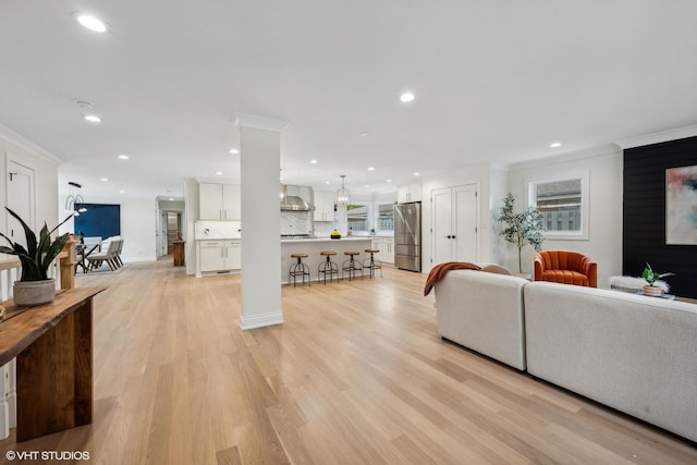 living room featuring crown molding and light hardwood / wood-style flooring