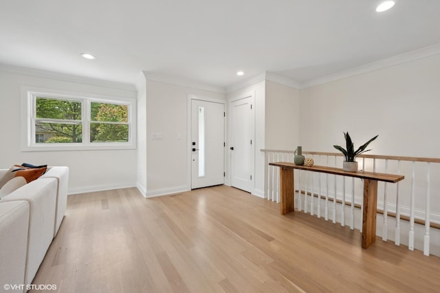 foyer entrance with light hardwood / wood-style floors and crown molding