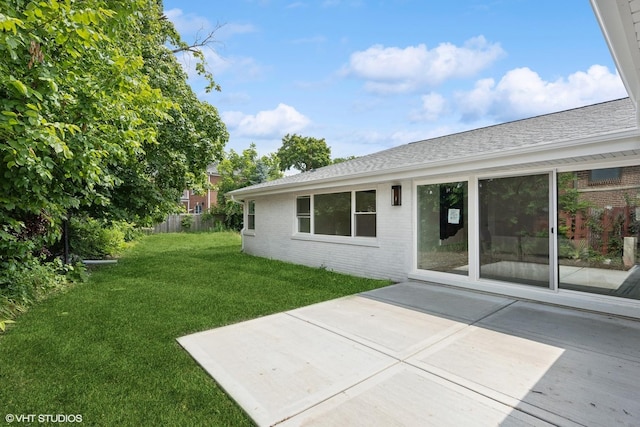 back of house with a lawn and a patio area