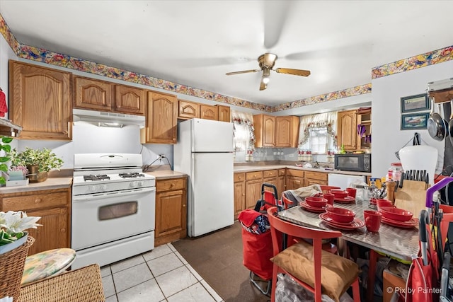 kitchen featuring light tile patterned flooring, white appliances, and ceiling fan